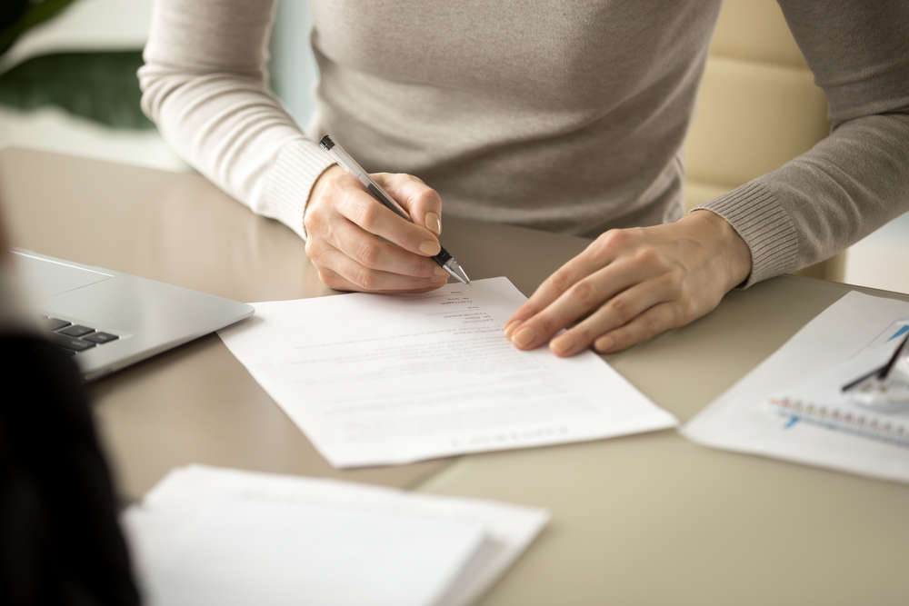 Mulher examinando contrato de prestação de serviços educacionais